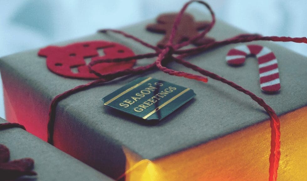 A neatly wrapped gift with a black tag and red string bow.