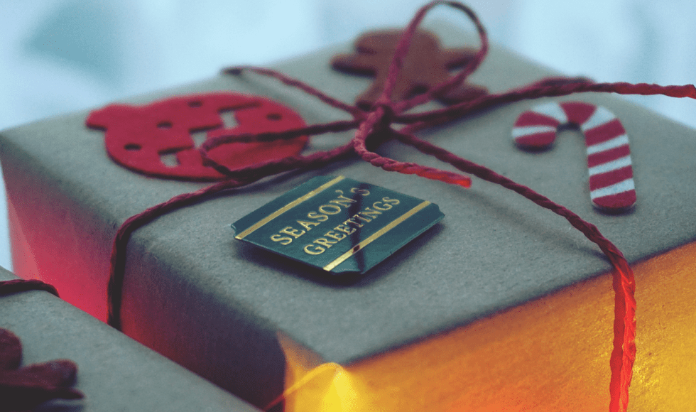 A neatly wrapped gift with a black tag and red string bow.