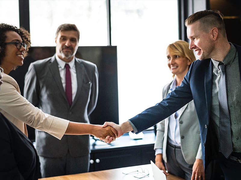 Business professionals shaking hands in a meeting room.