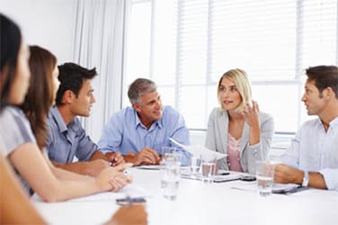 A group of professionals having a discussion in a bright office.