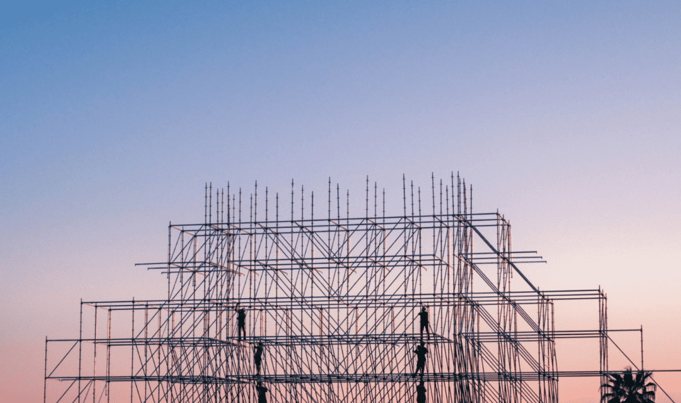 Steel scaffolding structure against a clear sky at dusk.