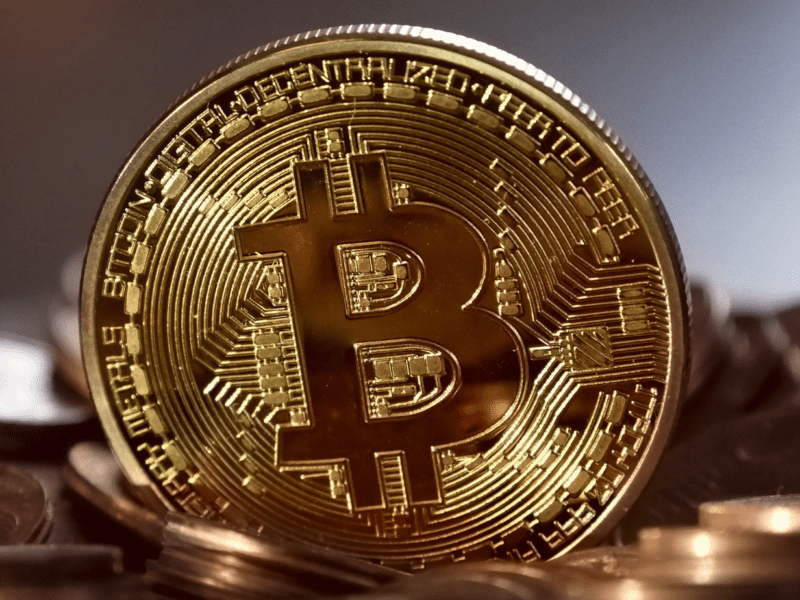 Close-up of a shiny gold Bitcoin coin symbolizing cryptocurrency.
