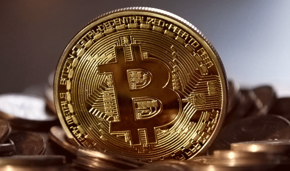 Close-up of a shiny gold Bitcoin coin symbolizing cryptocurrency.
