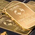 Stack of 100g fine gold bars with global design.