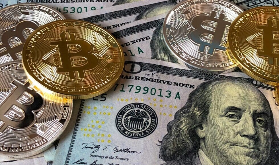 Bitcoin coins placed on US dollar bills symbolizing cryptocurrency and finance.