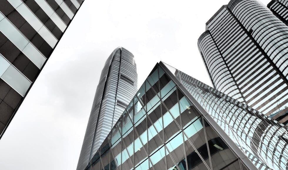 Modern skyscrapers with reflective glass under an overcast sky.