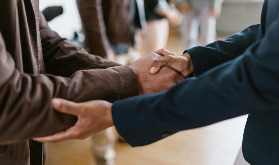 Two people holding hands in a comforting gesture.
