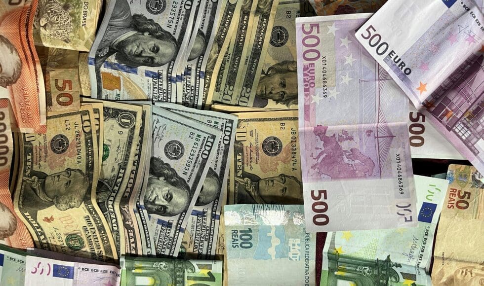 Various US dollars and euros spread out on a surface.