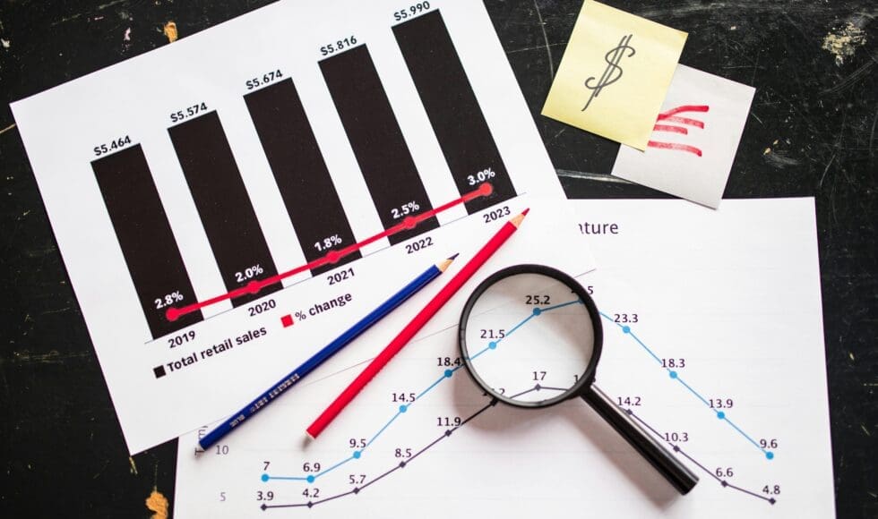 Magnifying glass, pencils, and charts showing data analysis.