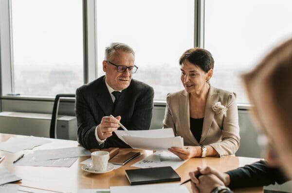 Business professionals discussing documents in a meeting room.